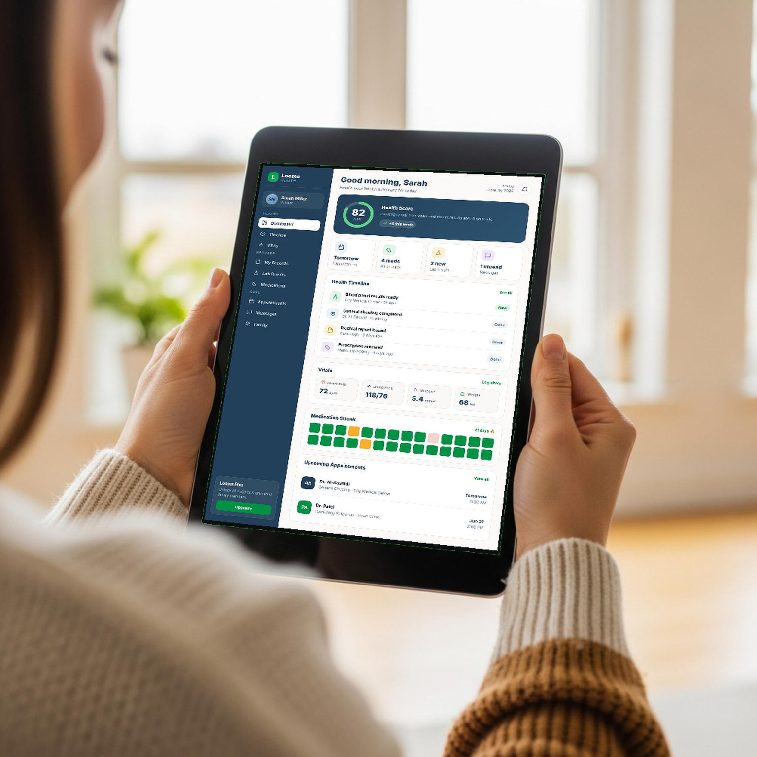 A woman holding an iPad showing the Looms health dashboard